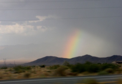 [Partial rainbow appearing to come out of distant hills arcing from lower left to upper right.]