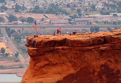 [Closeup view as seen from the long side. Approximately 9 or so people are on top and  about 3 more one level down. Flag is at the top.]