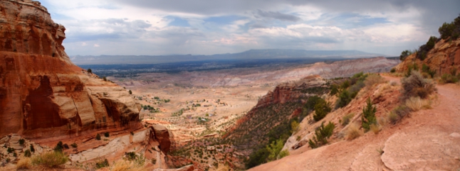 [Two photos stitched together showing a drop into a valley. One can see for miles to the Book Cliffs in the far distance.]