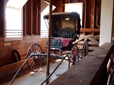 [Open, 2-seater carriage with rooftop and backing meant to be pulled by one horse.]