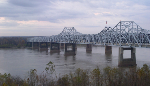 [Two photos stitched together to create the entire scene. A light-colored steel bridge in foreground almost completely hides the dark-colored metal bridge beside it.]