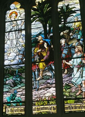 [This three panel window has a man traveling on a horse with others around him on foot. There is a man in the sky in robes. The words at the bottom of the window are, 'In thy see shall all the nations of the earth be blessed.']