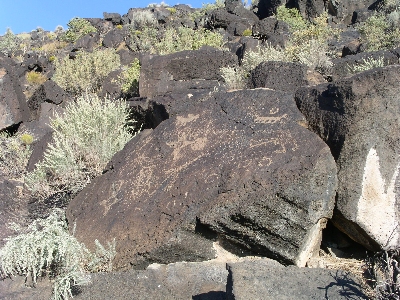 [Dark brown rock with tan sympbols etched on the surface.]