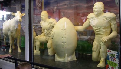 [Cows and football players carved from butter in a temperature controlled display.]