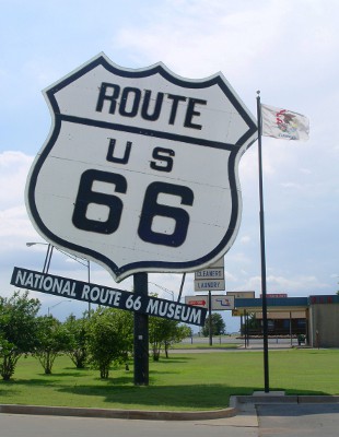 [Huge route 66 symbol sign on a post near the road outside the museum complex.]