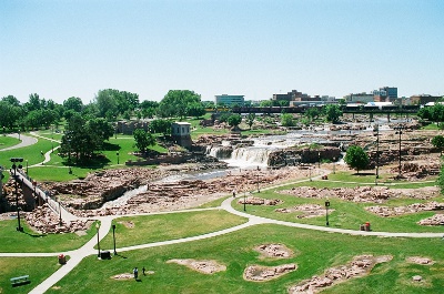 [view of falls, grass, and lots of rocks in grassy area (cause this rock is hard and thus hard to remove).]