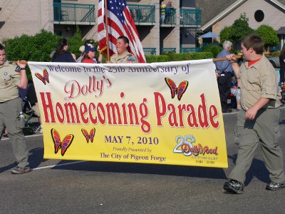 [Boy scouts carrying flying specifying parade name and date.]