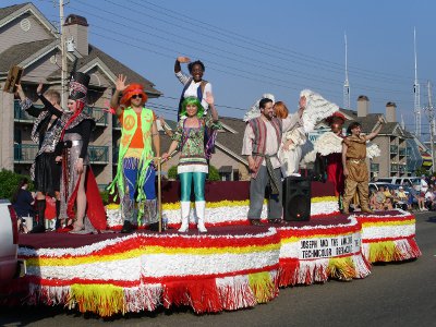 [Colorful cast members atop a float.]